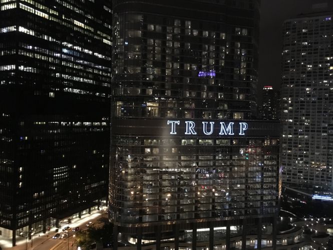 Trump toren in de nacht, verlicht met ramen en auto's op straat.