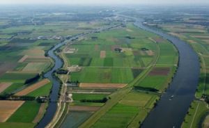 Breed kanaal, omgeven door polders en landbouwgrond.