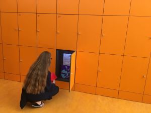 Vrouw met lange haren bekijkt een open kastje met documenten en een LP van Joe G.