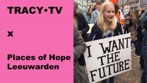 Jong meisje houdt bord omhoog met tekst: "I WANT THE FUTURE". Links tekst: TRACY•TV X Places of Hope Leeuwarden.