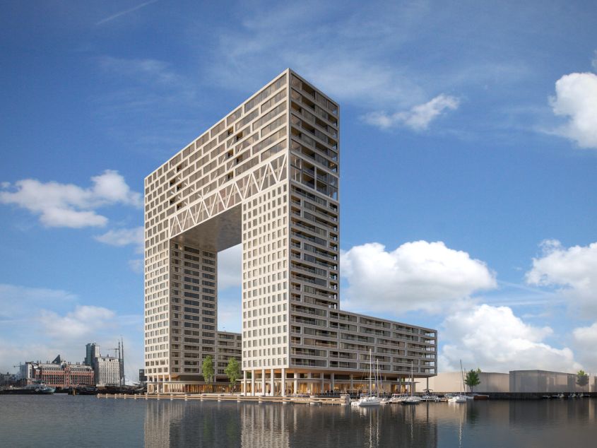 Modern gebouw met grote boog bij een haven met boten en een blauwe lucht.