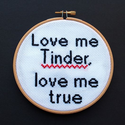 Borduurwerk met tekst "Love me Tinder, love me true" met rode zigzaglijn.