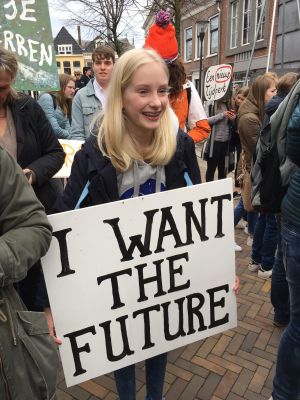 Meisje met bord "I WANT THE FUTURE" op demonstratie.