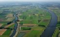 Breed kanaal, omgeven door polders en landbouwgrond.