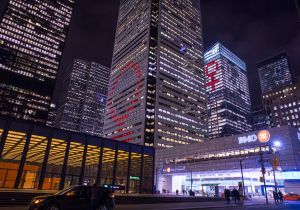 Torenhoge gebouwen verlicht met rode en witte lichten, BMO Bank of Montreal logo, nacht, auto.